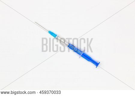 Blue Medical Disposable Syringe For Injection On A White Background. Medical Instrument For Vaccinat