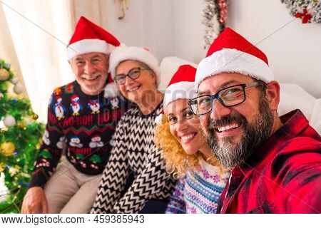 Group Of Four People Smiling And Lookind At The Camera Of The Young Man Holding The Camera - Family 