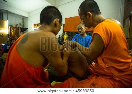 NAKHON CHAI, Tajlandia - MAR 23: Niezidentyfikowane mnich sprawia, że tradycyjne Yantra tatuażu w Wai pełna