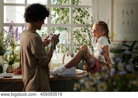 Young Woman With Photocamera Looking Through Images Of Her Daughter