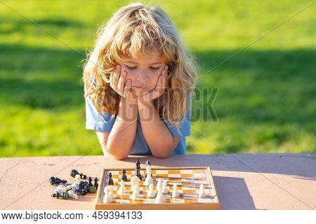 Kid Playing Chess. Intelligent, Smart Ass Kids. Games Good For Brain Intelligence Concept.