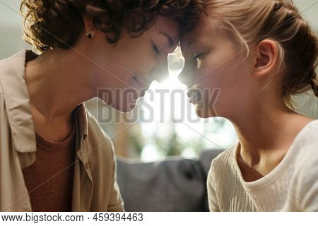 Side View Of Young Smiling Brunette Woman And Cute Blond Youthful Girl