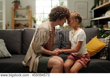 Young Careful Woman In Casualwear Bending Slightly Forwards To Her Daughter