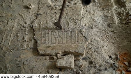 Concrete Rubble At The Construction Site Of A House. Destruction Of Old Tiles. The Builder Breaks Th