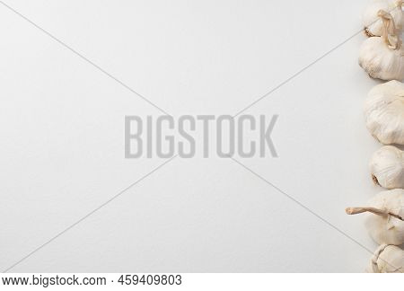 Garlic Cloves And Bulb On White Table With Space For Your Text