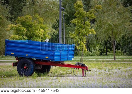Two-wheeled Car Metal Trailer Stands In The Parking Lot. High Quality Photo