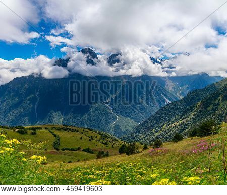 View Of Huge Mountains With Waterfalls And Beautiful Clouds In North Ossetia.
