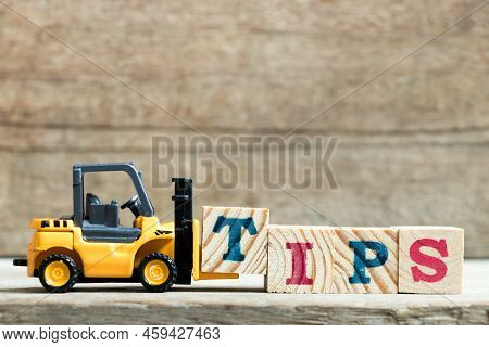 Toy Yellow Forklift Hold Letter Block T To Complete Word Tips On Wood Background