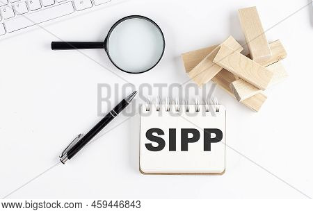 Self-invested Personal Pension Sipp Word Written On Notebook With Block Magnifier And Pen , Business