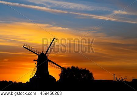 Early In The Morning There Is A Beautiful Windmill Whit The Sun Rising In The Sky