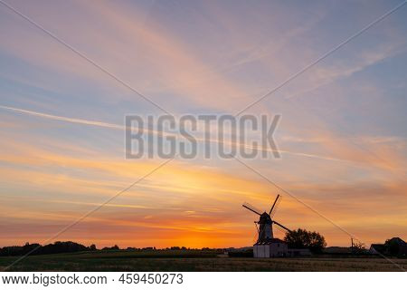 Early In The Morning There Is A Beautiful Windmill Whit The Sun Rising In The Sky