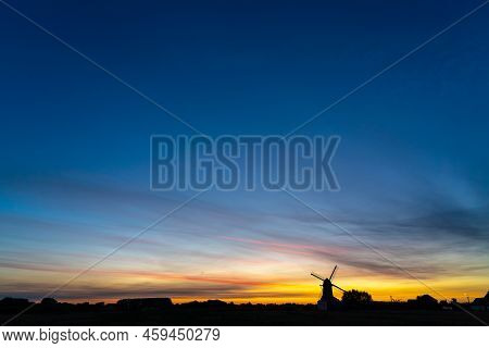 Early In The Morning There Is A Beautiful Windmill Whit The Sun Rising In The Sky