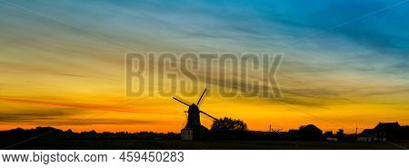 Early In The Morning There Is A Beautiful Windmill Whit The Sun Rising In The Sky