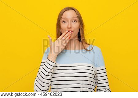 Portrait Of Fair-haired Girl With Guilty Big Eyes Looks Confused, Cover Mouth Lips Hand On Mouth, We