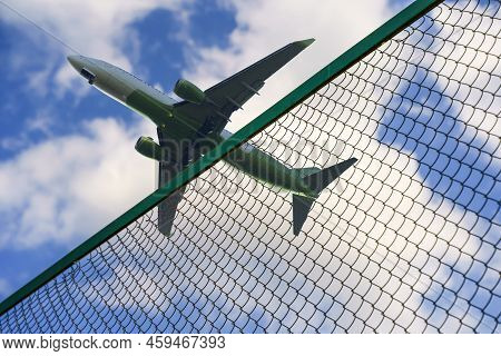 Plane Taking Off Against The Background Of The Fence And The Border Of The Airport. Tourism, Busines