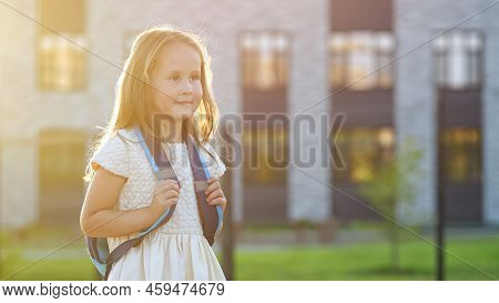 Happy Girl Goes To School With Blue Backpack Smiling. Preschooler Girl Enjoys Walking To Preparatory