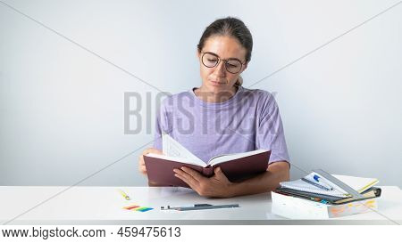 Student Turns The Page Of A Book Or Textbook. High Quality Photo