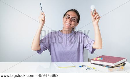 A Joyful Student With A Pencil And A Light Bulb, An Idea Or Answer Came During Her Studies. High Qua