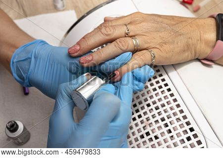 The Manicurist Applies A Topcoat With Black Dots To The Finished Hybrid Nails With A Brush.