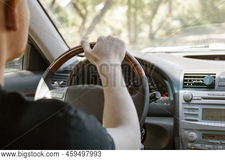 A Man Driving A Car, Rear View From The Passenger Compartment. Safe Driving.