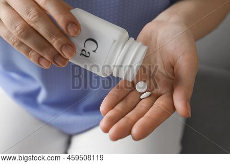 Calcium Supplement. Woman Taking Pills Indoors, Closeup