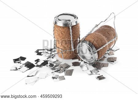 Corks Of Sparkling Wine With Muselet Caps And Shiny Silver Confetti On White Background