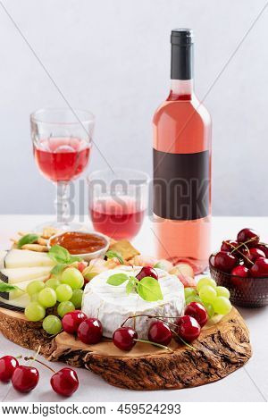 Set Table With Bottle Of Rose Wine Mockup, Wine Glasses, Cheese Board And Fruits On Light Gray Backg