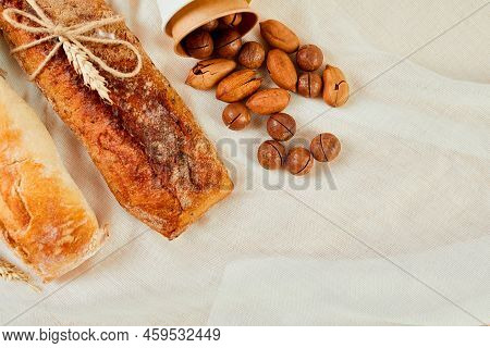 Top View Of Two Baguettebread And Nuts On A Textile Surface.