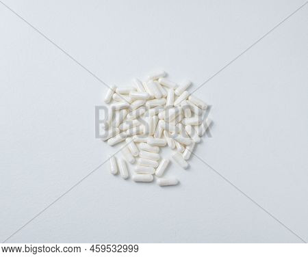 Pile Of White Pills On White Table. Top View Of Pile White Pill Painkiller.