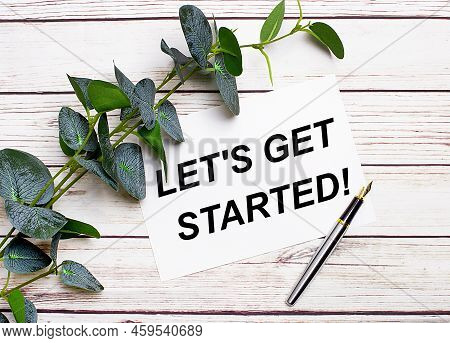 On A Light Wooden Table, There Is A Eucalyptus Branch, A Fountain Pen And A Sheet Of Paper With The 