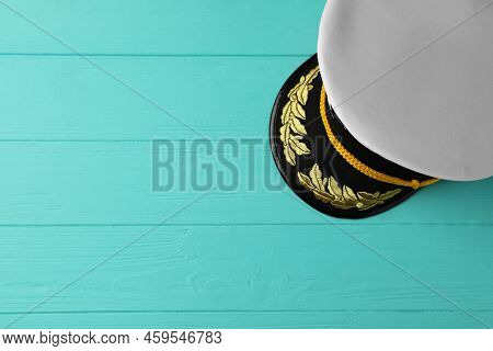 Peaked Cap With Accessories On Turquoise Wooden Background, Top View. Space For Text
