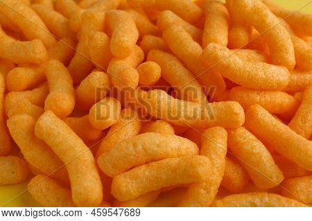 Tasty Cheesy Corn Puffs As Background, Closeup