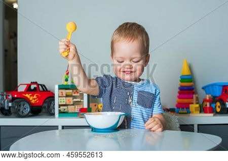 Toddler Boy Eats With Spoon And Is Covered In Food. Baby Food, Food Allergies, Self-feeding....