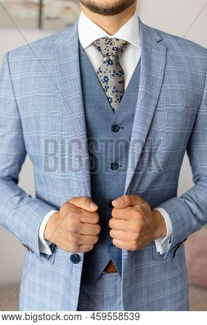 Cropped Photo Of Man Groom Wearing Blue Stylish Checkered Suit, Vest, White Shirt, Grey Tie, Holding