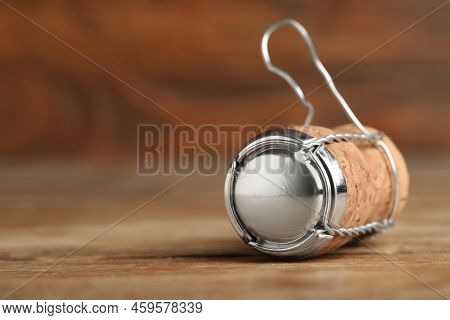 Sparkling Wine Cork With Muselet Cap On Wooden Table, Closeup. Space For Text