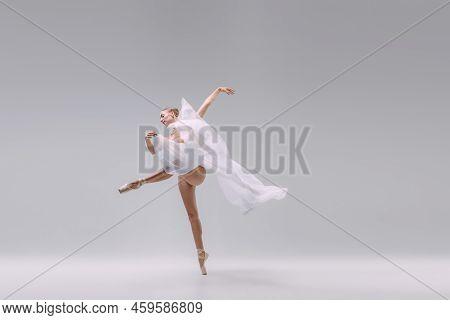 Portrait Of Young Gracefull Ballerina Dancing With Transparent White Fabric Isolated Over Grey Studi