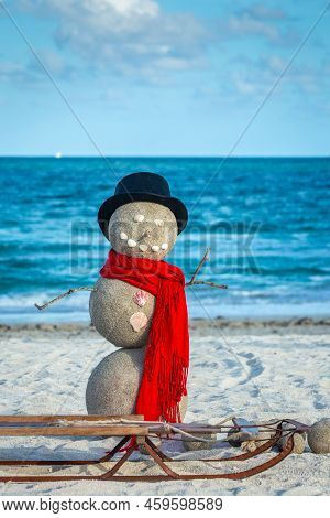 Snowman With Red Scarf, Hat And Sled On The South Miami Beach, Florida