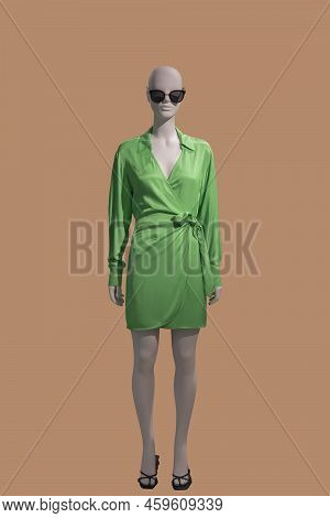 Full Length Image Of A Female Display Mannequin Wearing Elegant Green Dress Isolated On A Pink Backg