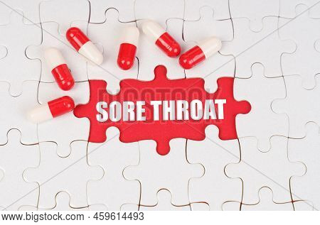 Medical Concept. There Are Pills On The White Puzzles, In The Middle There Is A Red Surface With The