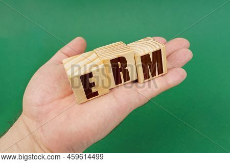 Business Concept. On A Green Background, In The Hands Of A Person, Cubes With The Inscription - Erm