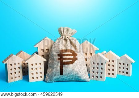 Philippine Peso Money Bag Among Town Houses Figurines. Rental Business. Municipal Budgeting. Rich Ci