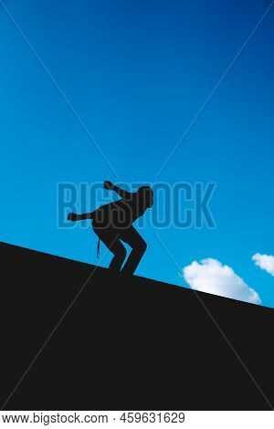 Black Silhouette Of A Man About To Do A Backflip With The Sky In The Background.