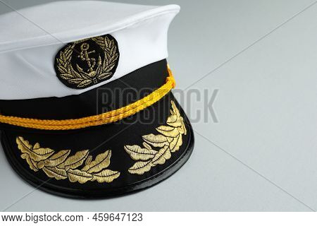 Peaked Cap With Accessories On Light Grey Background, Closeup. Space For Text