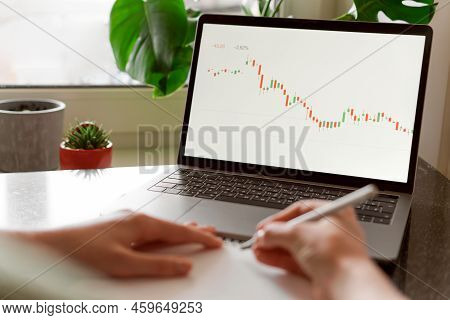 Female Hands Writing Down Numbers From Laptop. Investment Analysis, Trading Concept. Technology, Dig