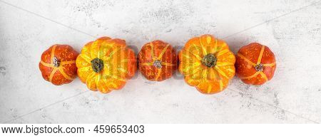 Thanskgiving Flat Lay With Yellow And Orange Pumpkins On Bottom Border Against White Background.copy