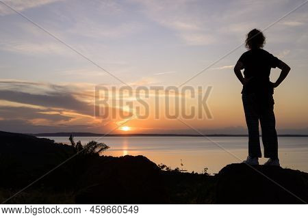 Kalangala, Uganda - May 10, 2022: Standing Girl Watching Colorful Sunset Near Kalangala (ssese Islan