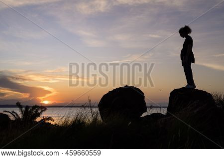 Kalangala, Uganda - May 10, 2022: Standing Girl Watching Colorful Sunset Near Kalangala (ssese Islan