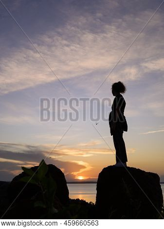 Kalangala, Uganda - May 10, 2022: Standing Girl Watching Colorful Sunset Near Kalangala (ssese Islan