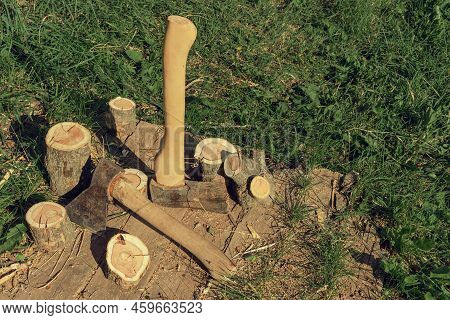 Axes Near Wooden Chocks. Preparation Of Firewood For Kindling. Stumps With Axes, Illuminated By Dayl
