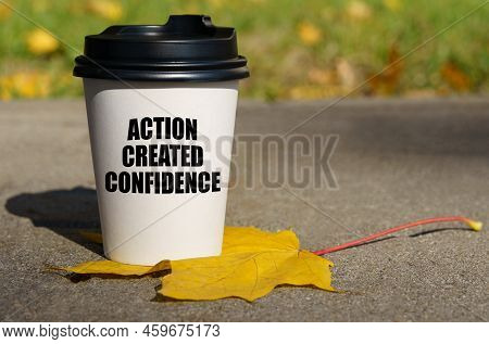 On A Yellow Maple Leaf There Is A Cup Of Coffee On Which Is Written - Action Created Confidence. Bus